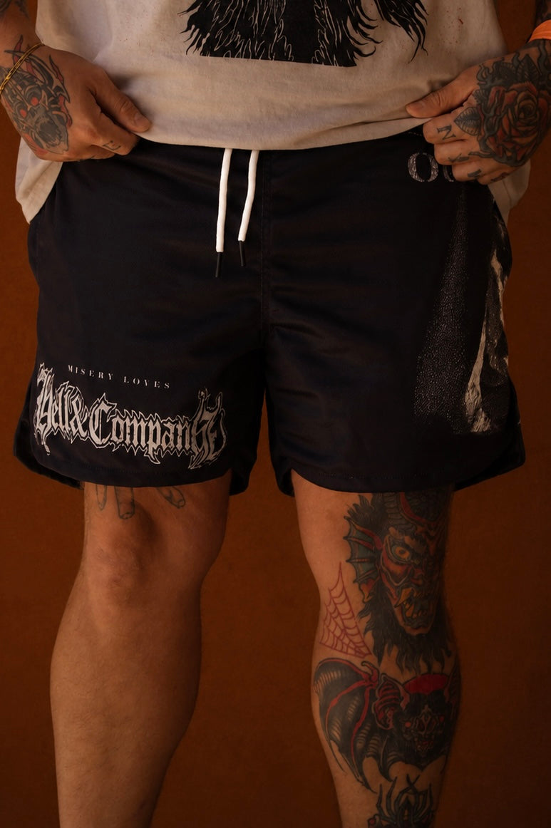 Person wearing black shorts with white text on a brown background