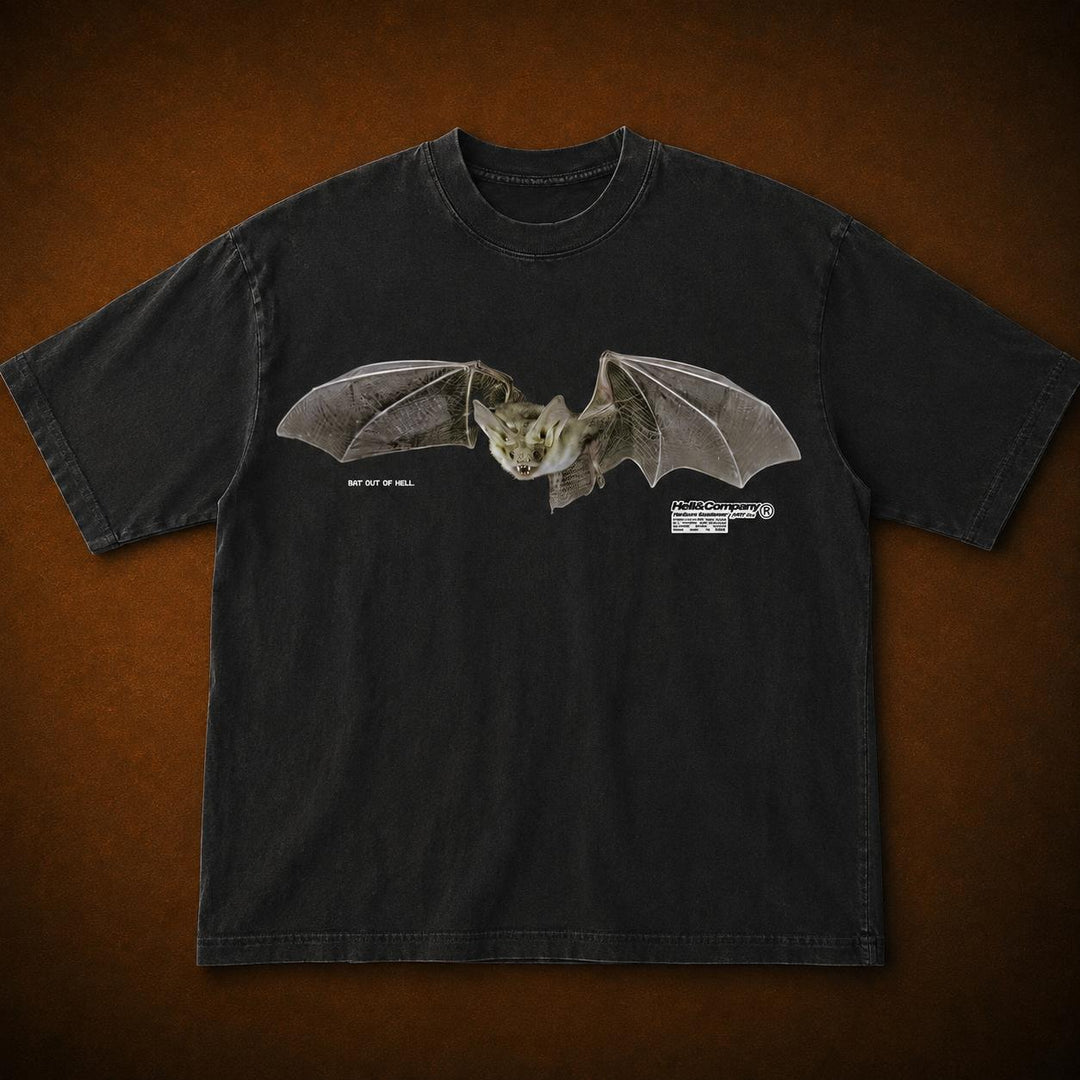 A black short-sleeve t-shirt featuring a detailed graphic of a flying bat on the chest, displayed flat against a textured brown background.