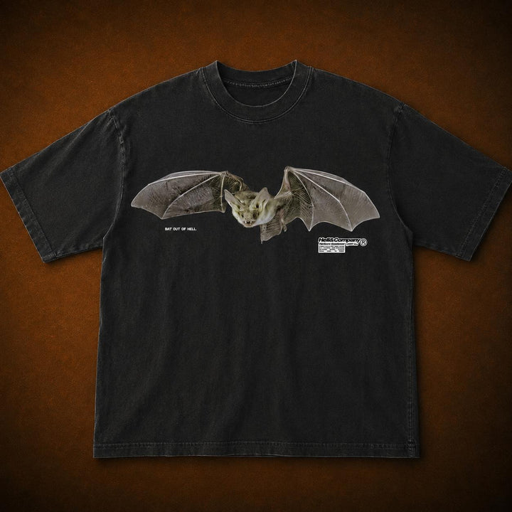 A black short-sleeve t-shirt featuring a detailed graphic of a flying bat on the chest, displayed flat against a textured brown background.